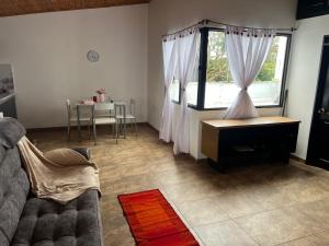 a living room with a couch and a table and a window at Casa Armonía Popayán in Popayan