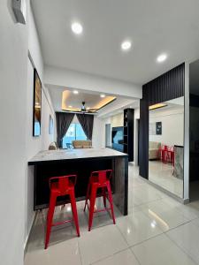 a kitchen with two red bar stools in a room at Cloud Nine Homestay in Tanah Rata