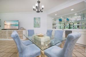 a dining room with a glass table and blue chairs at Phoenix on the Bay 1217 in Orange Beach