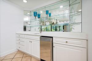 a kitchen with white cabinets and glass shelves at Phoenix on the Bay 1217 in Orange Beach