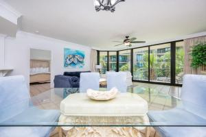 a living room with a glass table and chairs at Phoenix on the Bay 1217 in Orange Beach