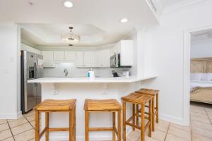 a kitchen with three bar stools and a counter at Phoenix on the Bay 1217 in Orange Beach