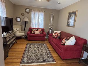 ein Wohnzimmer mit zwei roten Sofas und einem Fernseher in der Unterkunft Craft Cottage in Berea