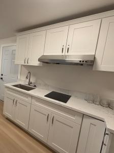 a white kitchen with white cabinets and a sink at Modern 2BR 2BA Apartment Garden-View in San Francisco