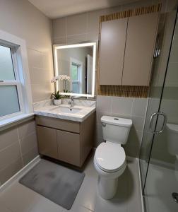 a bathroom with a toilet and a sink and a mirror at Modern 2BR 2BA Apartment Garden-View in San Francisco