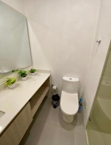 a white bathroom with a toilet and a mirror at Suite D’lujo: Jacuzzi privado BH in Santa Marta