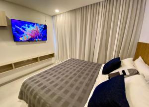 a bedroom with a bed and a tv on the wall at Suite D’lujo: Jacuzzi privado BH in Santa Marta