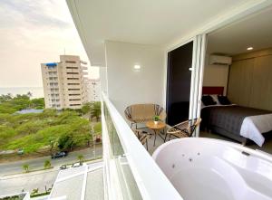 a bathroom with a tub and a bed and a balcony at Suite D’lujo: Jacuzzi privado BH in Santa Marta