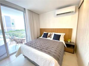 a bedroom with a large bed and a balcony at Suite D’lujo: Jacuzzi privado BH in Santa Marta