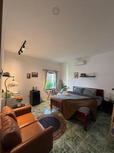 a bedroom with a bed and a couch at Gác Homestay Phan Thiết in Ấp Sung Xuân