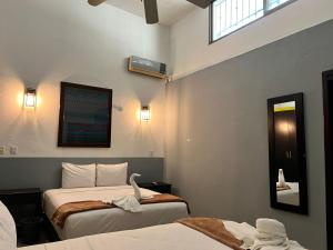 a bedroom with two beds and a swan on the bed at Casa Papalo in Palenque