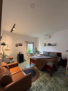 a bedroom with a bed and a couch at Gác Homestay Phan Thiết in Ấp Sung Xuân