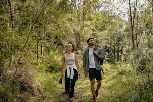 a man and a woman walking down a forest trail at The Lookout - a Huch experience in Wollombi +29 photos