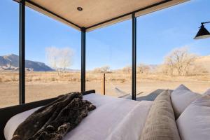 a bedroom with a bed and a large glass window at Luxury Glass Tiny House and Sauna in Torrey