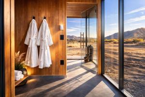 a bathroom with a glass door with a view of the desert at Luxury Glass Tiny House and Sauna in Torrey