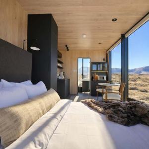 a bedroom with a large bed and a table at Luxury Glass Tiny House and Sauna in Torrey +39 photos