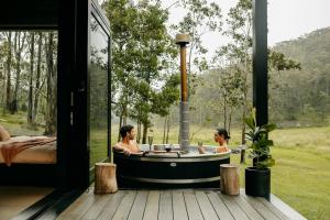 two women in a bathtub in a room with a view at The Lookout - a Huch experience in Wollombi
