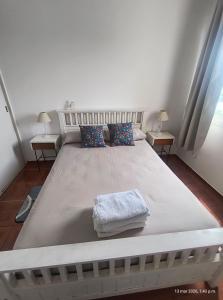 a large white bed in a room with two tables at Vista sur in Buenos Aires
