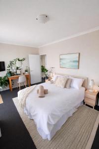a large white bed with two stuffed animals on it at Apollo Stayz Luxury Waterfront Home 57 - Pool - Spa - Jetty in Mandurah +16 photos