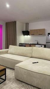 a living room with two white couches and a kitchen at Instant Charnel Sauna et Jacuzzi Privatif in Istres