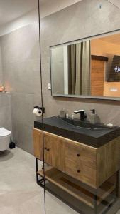 a bathroom with a sink and a mirror at Instant Charnel Sauna et Jacuzzi Privatif in Istres