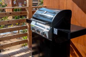 a grill hanging on a wall next to a fence at Glamping Trailer Lanikai in Awaji