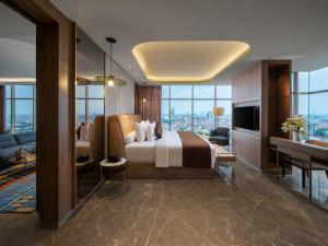 a hotel room with a bed and a desk and a television at MORAZEN Surabaya in Surabaya +20 photos