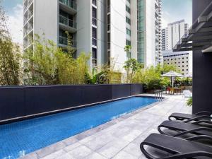 a swimming pool with lounge chairs next to a building at Mantra on Mary in Brisbane