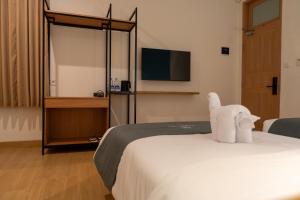 a hotel room with a bed and a tv at Anamcara Hotel & Convention in Cipanas