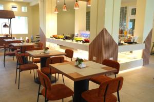 a restaurant with tables and chairs and a counter at Anamcara Hotel & Convention in Cipanas