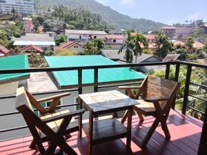 a balcony with chairs and a table and a view at Hi Karon Beach in Karon Beach
