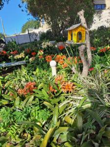 a garden with a bird house and flowers at Coastal Cottage in Klein-Brakrivier