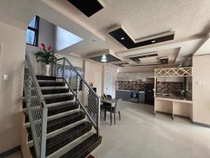 a living room with a staircase and a kitchen at Rweydz Guest Inn in Tagbilaran City