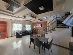 a living room with a table and a staircase at Rweydz Guest Inn in Tagbilaran City