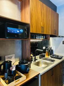 eine Küche mit Spüle und Herd mit Töpfen und Pfannen in der Unterkunft Sten Haven Suite in Bacolod City