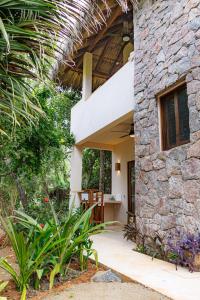 a stone house with a porch with a stone wall at Villas Indigo Troncones in Troncones