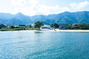 a body of water with houses and mountains in the background at RIPSTICK Private Luxury Resort in Otsu