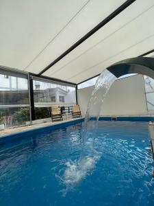 a water fountain in a swimming pool at Hotel Pleno Sol in Villa Gesell