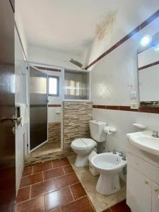 a bathroom with a toilet and a shower and a sink at Hotel Pleno Sol in Villa Gesell
