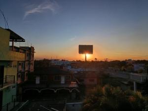 a sunset over a city with a water tower in the background at Hotel Tropigalas in Tampamachoco