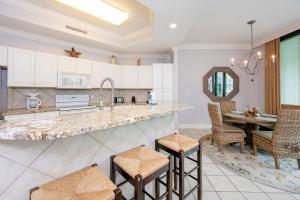 a kitchen with a counter and chairs and a table at Phoenix on the Bay 1129 condo in Orange Beach