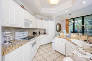 a kitchen with white cabinets and a sink at Phoenix on the Bay 1129 condo in Orange Beach
