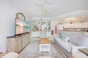 a living room with a couch and a tv at Phoenix on the Bay 1129 condo in Orange Beach