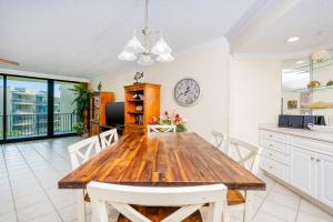a dining room with a wooden table and a clock at Phoenix on the Bay 1415 in Orange Beach