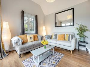 a living room with a couch and a table at Wisteria Cottage in Heathfield