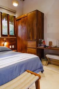 a bedroom with a bed and a wooden cabinet at Villas Indigo Troncones in Troncones