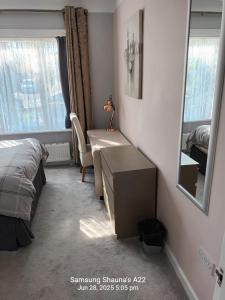 a bedroom with a bed and a desk and a mirror at Shauna's house in Poole