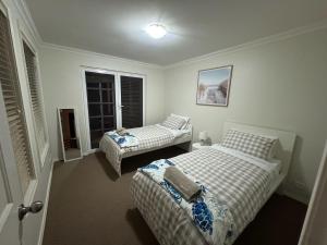 a bedroom with two beds and a window at Beach Haven in Bunbury
