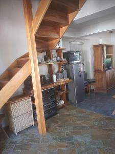 a kitchen with wooden stairs and a kitchen with a refrigerator at Aromas de Montaña VIP in Junín de los Andes +16 photos
