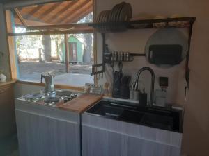 a kitchen with a sink and a stove and a window at Aromas de Montaña VIP in Junín de los Andes